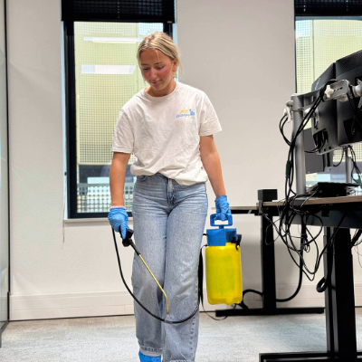 Isa, medewerker van Koen de Poetskampioen sprayt vrolijk een tapijt in.